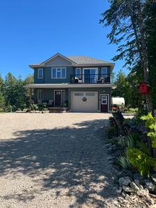 a blue house with a garage and a driveway at Tobermory Tides bed and breakfast in Tobermory