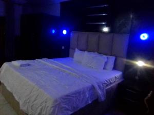 Cama en habitación oscura con luces azules en Flogate Hotel, en Enugu