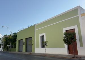 un edificio verde y blanco al lado de una calle en El Pueblo Mérida, en Mérida