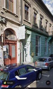 a blue car parked in front of a building at Wot Luxury Silver Center in Arad