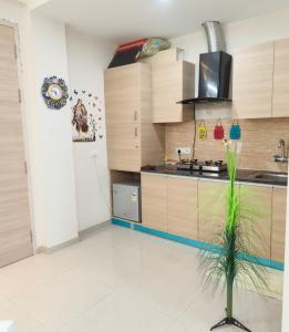 Una cocina con muebles de madera y una planta en el medio. en Mero vrindavan home stay, en Vrindāvan