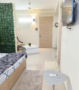 Un dormitorio con una cama y un televisor en una pared. en Mero vrindavan home stay, en Vrindāvan 20 fotos más