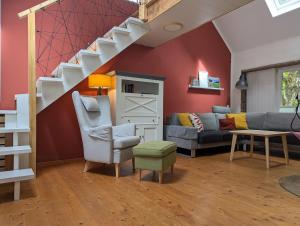 a living room with a couch and a staircase at Ferienhaus Eifelheide in Kall