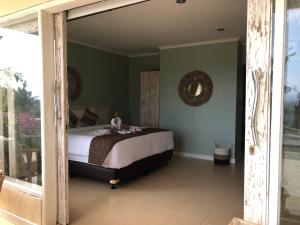 ein Schlafzimmer mit einem Bett in einem Zimmer mit grünen Wänden in der Unterkunft Soma Bloom Resort in Jembrana