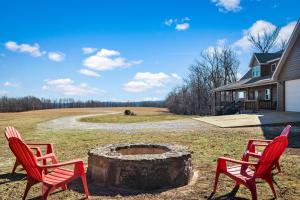 ParthenonOzark Retreat with Mountain Views Fire Pit & Deck的院子里有两把红色椅子和一个火坑