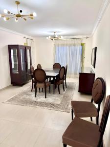 a dining room with a table and chairs at Elegant Apartment at Zayed Compound in Sheikh Zayed +19 photos