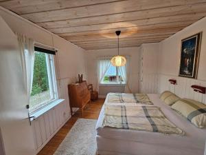 a bedroom with two beds and a wooden ceiling at Villa Nico in Älvsbyn