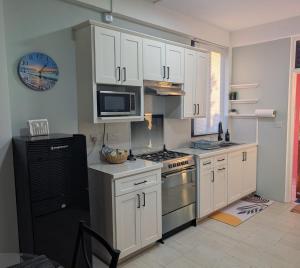 a kitchen with white cabinets and a stove top oven at Sunset Vista homely apartment in Méro