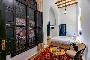 a bedroom with a bed and a table and a chair at Riad Dar Dialkoum in Marrakech +261 photos