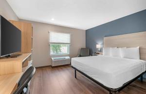 a bedroom with a bed and a flat screen tv at Extended Stay America Select Suites - Wildwood - The Villages in Wildwood +51 photos