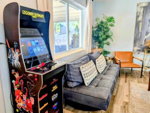 un soggiorno con una console per videogiochi accanto a un divano di Ranch Style, King Bed, Guitar, BBQ- 1 Dollar rides to Beach & Downtown a Lake Worth