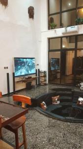 a living room with a flat screen tv and a couch at Le Chacal in Foumban