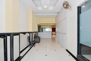 a hallway with white walls and a floor with white tiles at Hotel O Ashwarya Service Apartment in Navi Mumbai