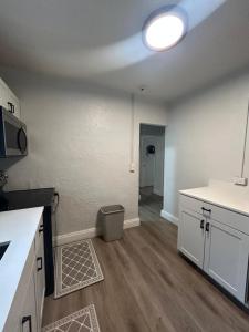 a kitchen with white cabinets and a counter top at Soothing bungalow with AC in Pompano in Pompano Beach +12 photos