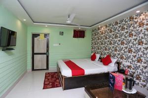 a bedroom with a bed and a tv in a room at Hotel O Mega Palace in Patna