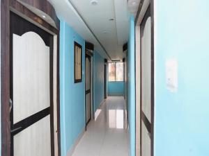 a hallway with blue walls and a door at Hotel O Mega Palace in Patna