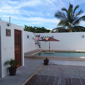 a house with a swimming pool and an umbrella at Casa Loto D in Chelem