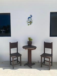 two chairs and a table and a clock on a wall at Casa Loto D in Chelem