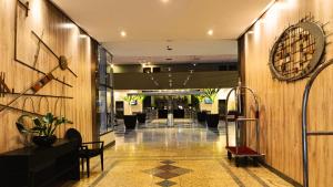a lobby of a hotel with a clock on the wall at GRU Airport Hotel - STAY HERE in Guarulhos +37 photos