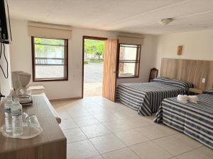 a hotel room with two beds and a window at Hotel Torre Molino in Monte Gordo