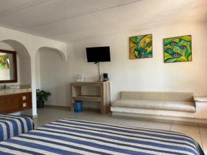 ein Zimmer mit einem Bett, einer Couch und einem Fernseher in der Unterkunft Hotel Torre Molino in Monte Gordo