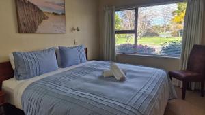 a bed with a white stuffed animal on top of it at Parkview Retreat- 3 Bedrooms and 3 Bathrooms in Napier
