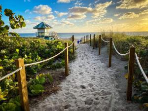 un sentiero per la spiaggia con un faro sullo sfondo di Farm Style, Bar Cart, Courtyard, BBQ- 1 Dollar rides to Beach & Downtown a Lake Worth