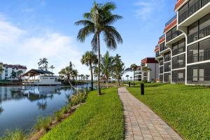 a path next to a river with palm trees and buildings at Pointe Santo C1 in Sanibel