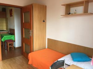 オルシュティンにあるKortowoのベッドルーム1室(オレンジのシーツが付いたベッド1台付)