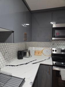 a kitchen with a white counter top with a stove at Little Heaven 2BR southwest Calgary in Calgary