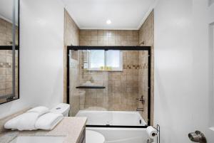 a bathroom with a tub and a toilet and a sink at WOW! Pickleball - Gym - Stylish Modern Living in Valrico +81 photos