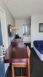 a hotel room with a table and a bed and a room with a bed at Queen Bed Hotel Room 232 in Amarillo