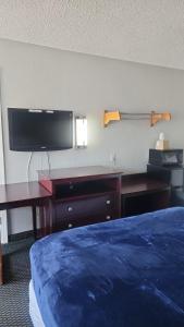a bedroom with a bed and a desk and a tv at Queen Bed Hotel Room 232 in Amarillo