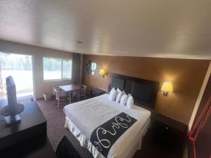 a hotel room with a large bed and a desk at Antlers Inn in Falfurrias