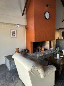 een woonkamer met een open haard en een witte bank bij Casa Calamo Hotel in Treinta y Tres