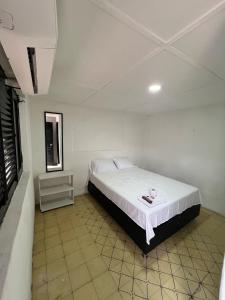 a bedroom with a bed in a white room at Hostal Valle in Valledupar
