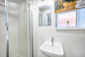 a white bathroom with a sink and a shower at H17B Cosy & Welcoming house & Private parking in Liversedge