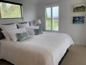 a white bedroom with a large white bed with pillows at Forty9 Steps in Russell
