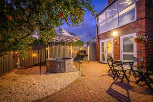 a patio with a fire pit and a table and chairs at H17B Cosy & Welcoming house & Private parking in Liversedge