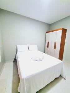 a white bedroom with a large white bed with cabinets at Refúgio do Preá - 700 Metros da Praia in Prea +26 photos