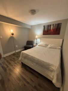 a bedroom with a bed and a chair in it at Fully Furnished 2 Bedroom Apartment in Kitchener