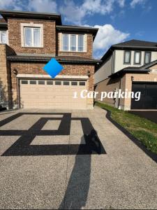 a driveway in front of a house with a car parking at Fully Furnished 2 Bedroom Apartment in Kitchener