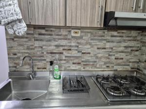 a kitchen counter with a sink and a stove at Apartamento centro de pereira a 2 cuadras del hospital san jorge in Pereira