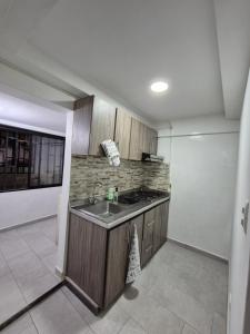a kitchen with a sink and a stove at Apartamento centro de pereira a 2 cuadras del hospital san jorge in Pereira