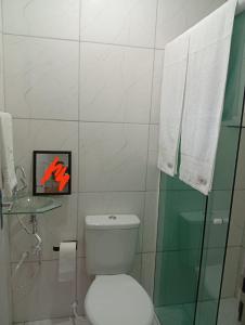 a bathroom with a toilet and a glass shower at Solar Curitiba Suites in Curitiba