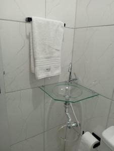a bathroom with a glass sink and a towel at Solar Curitiba Suites in Curitiba