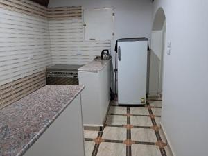 a kitchen with a refrigerator and a tile floor at Makky ka in Jazīrat Suhayl