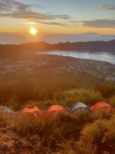 a group of tents on a hill at sunset at LuxeTent Batur Peak in Kintamani