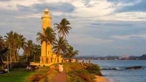 a man walking down a path in front of a lighthouse at Thambili House Galle Fort by Edwards Collection in Galle