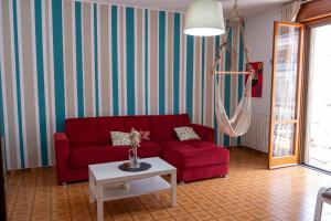 a living room with a red couch and a table at A casa di Filo in Boiano +8 photos